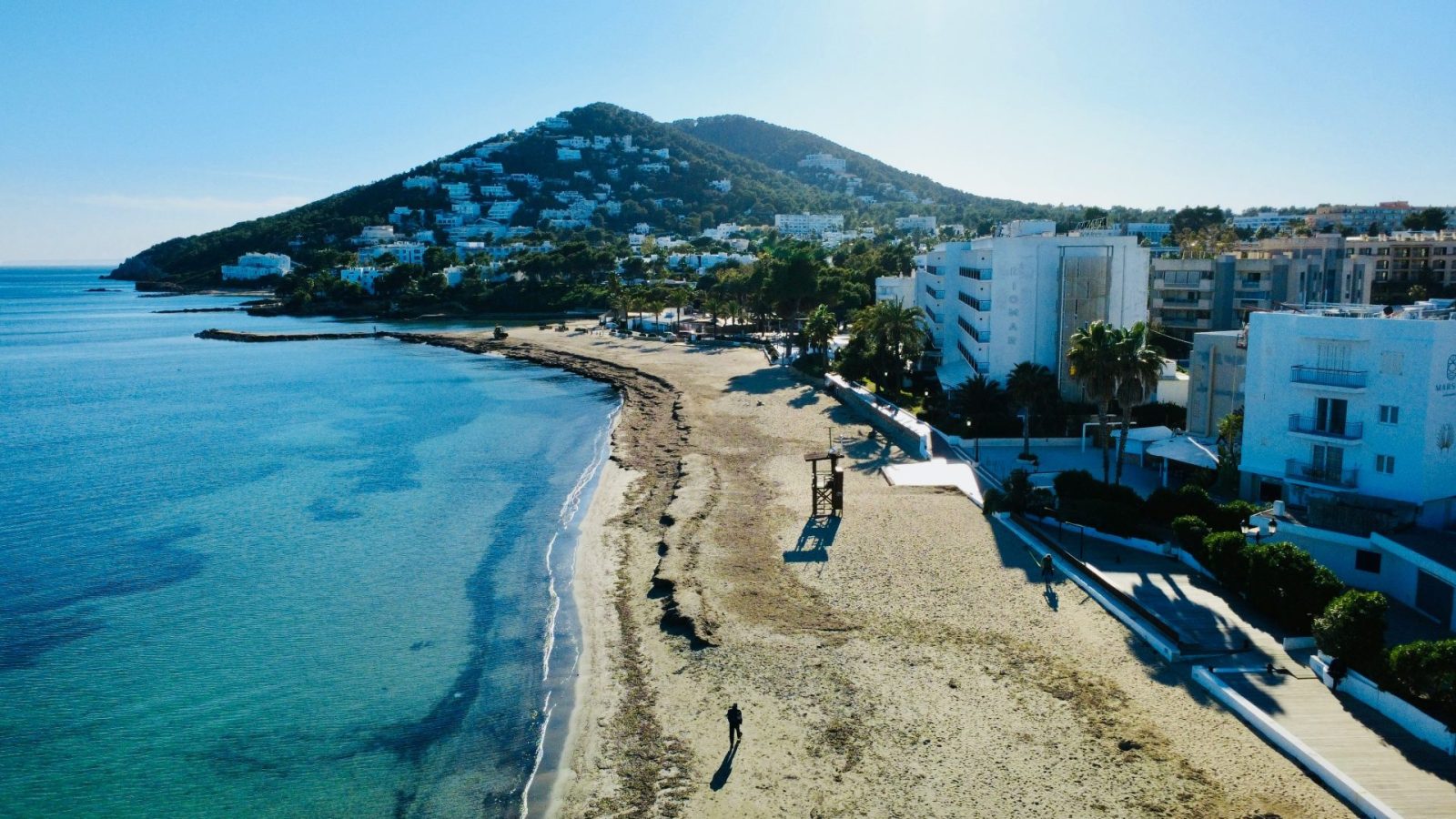 An aerial view of a beach with a mountain in the background